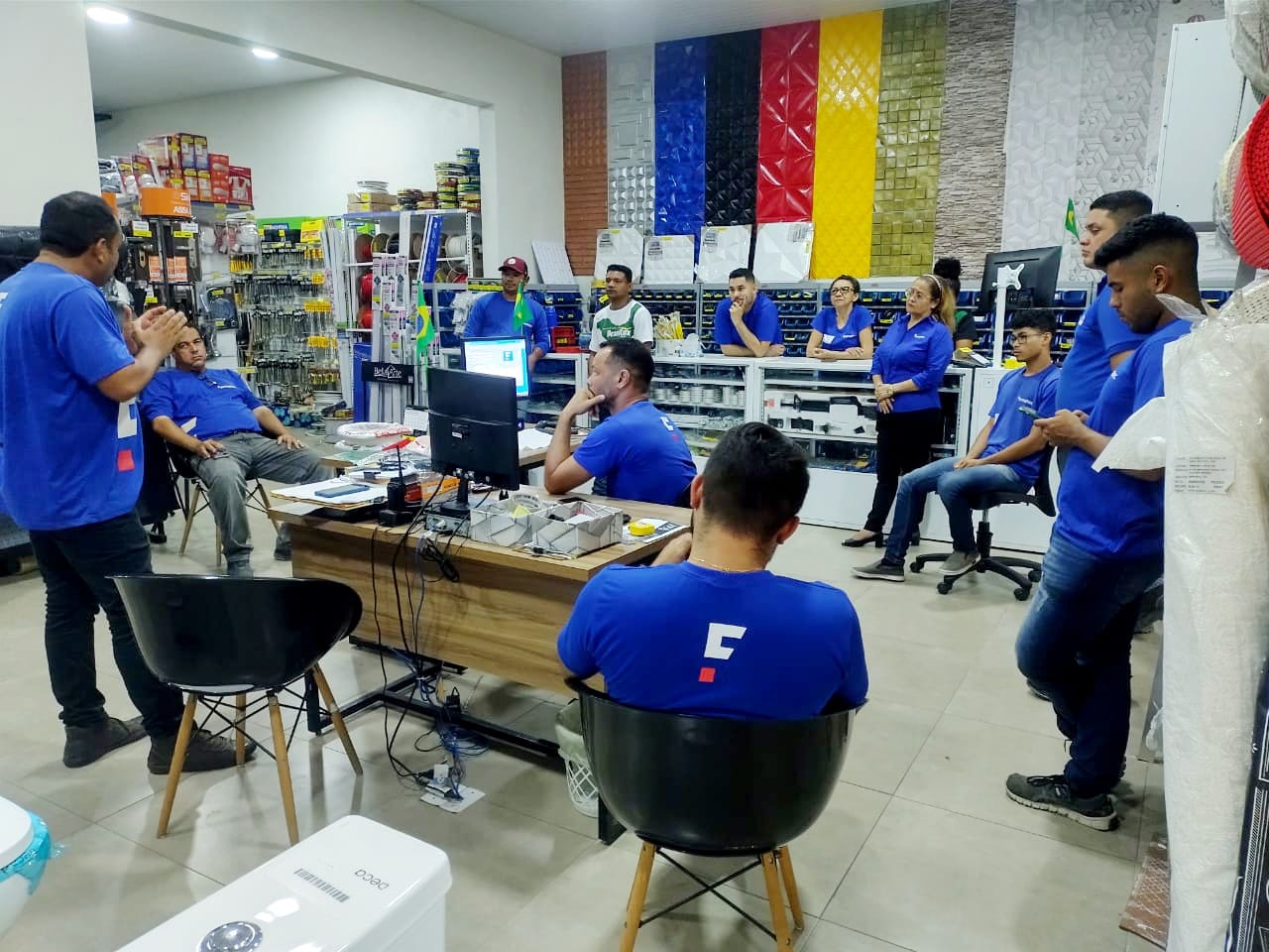 Equipe reunida no interior da Fermatec, com exposição de revestimentos ao fundo
